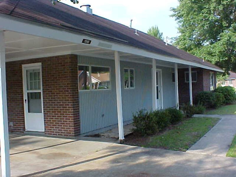 side entrance of white brick house with white siding