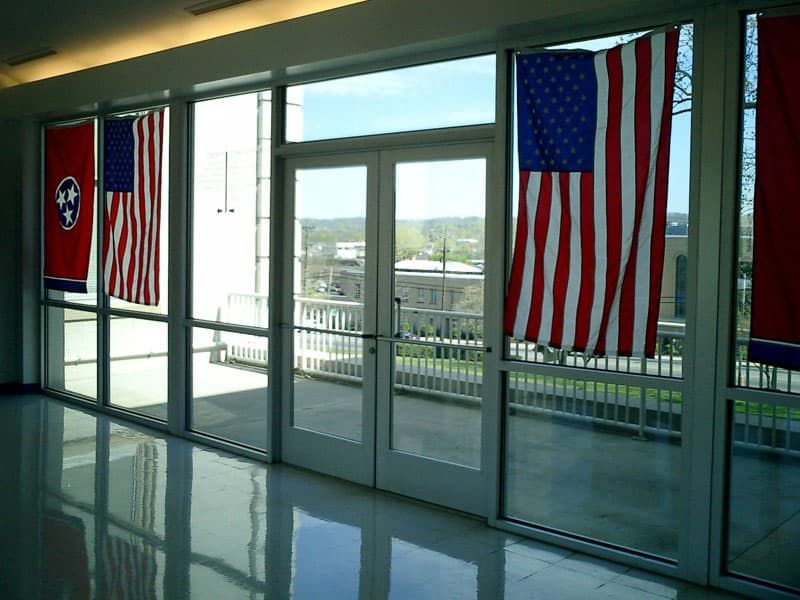 US and Tennessee state flags hanging on glass entrance