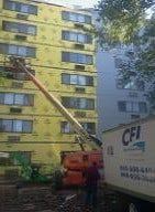boom lift in front of yellow apartment building