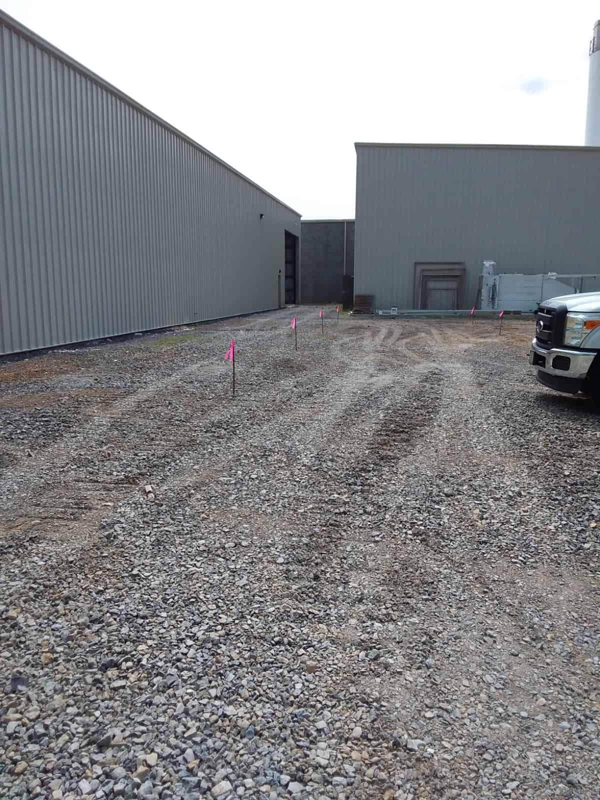 gravel ground leading to building and front of pickup truck