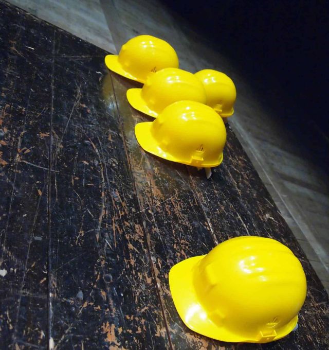 yellow hard hats on scratched dark wood