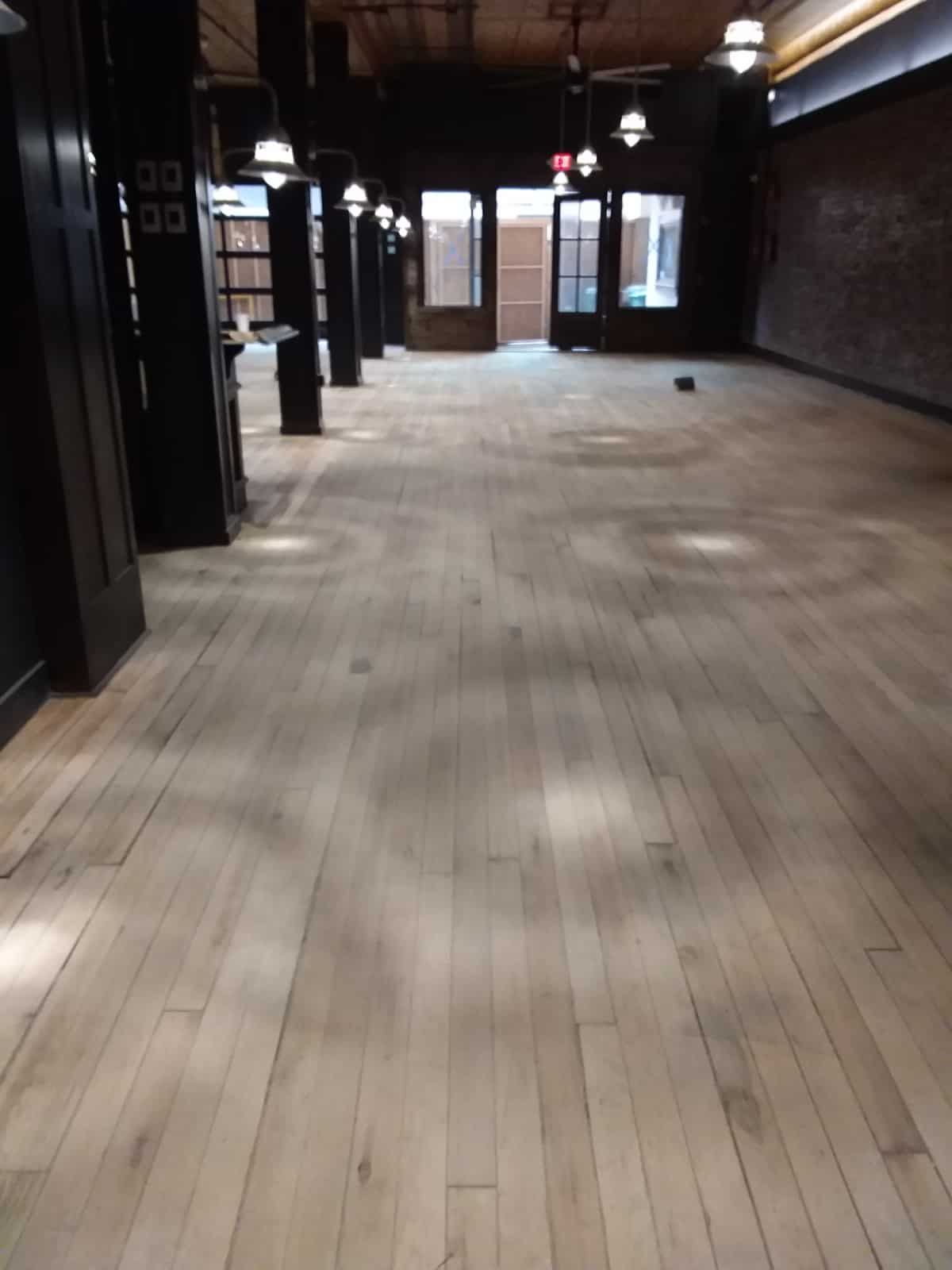 empty room with wood floors and hanging lights