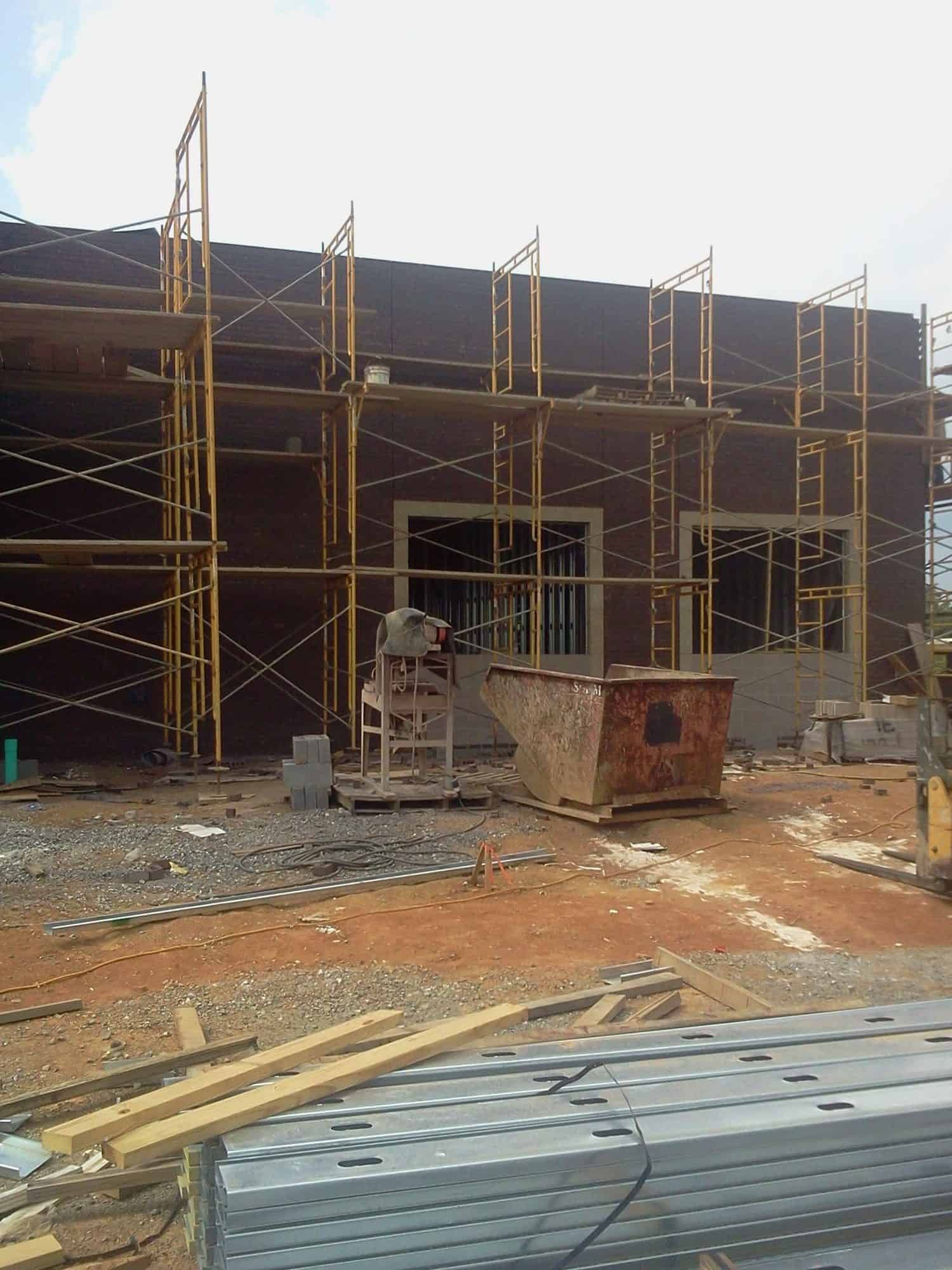 building frame with scaffolding behind construction materials