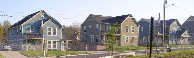 three preston taylor homes behind a chain link fence