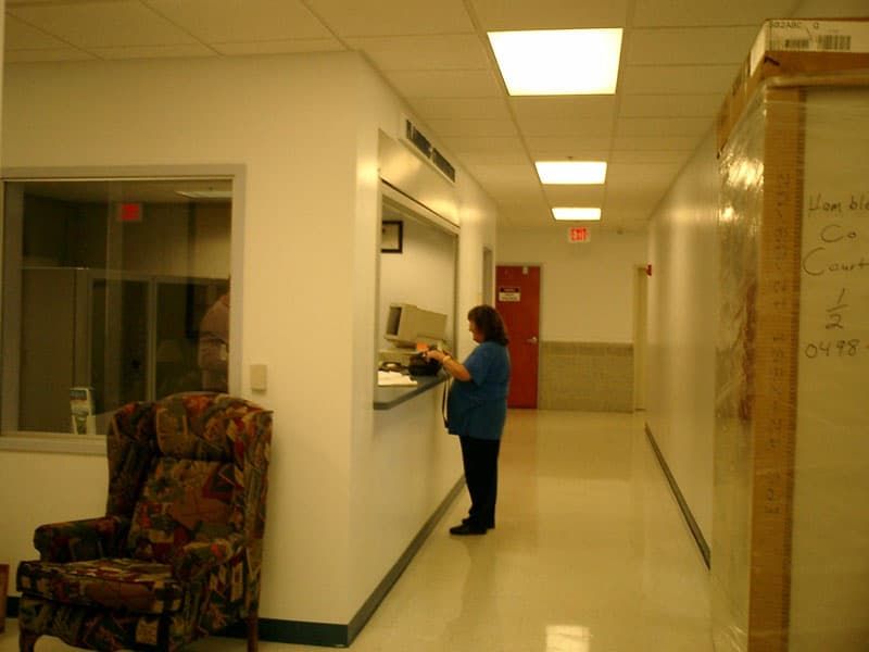 person at reception window, patterned chair in foreground