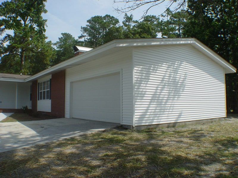 white garage of a red and white house